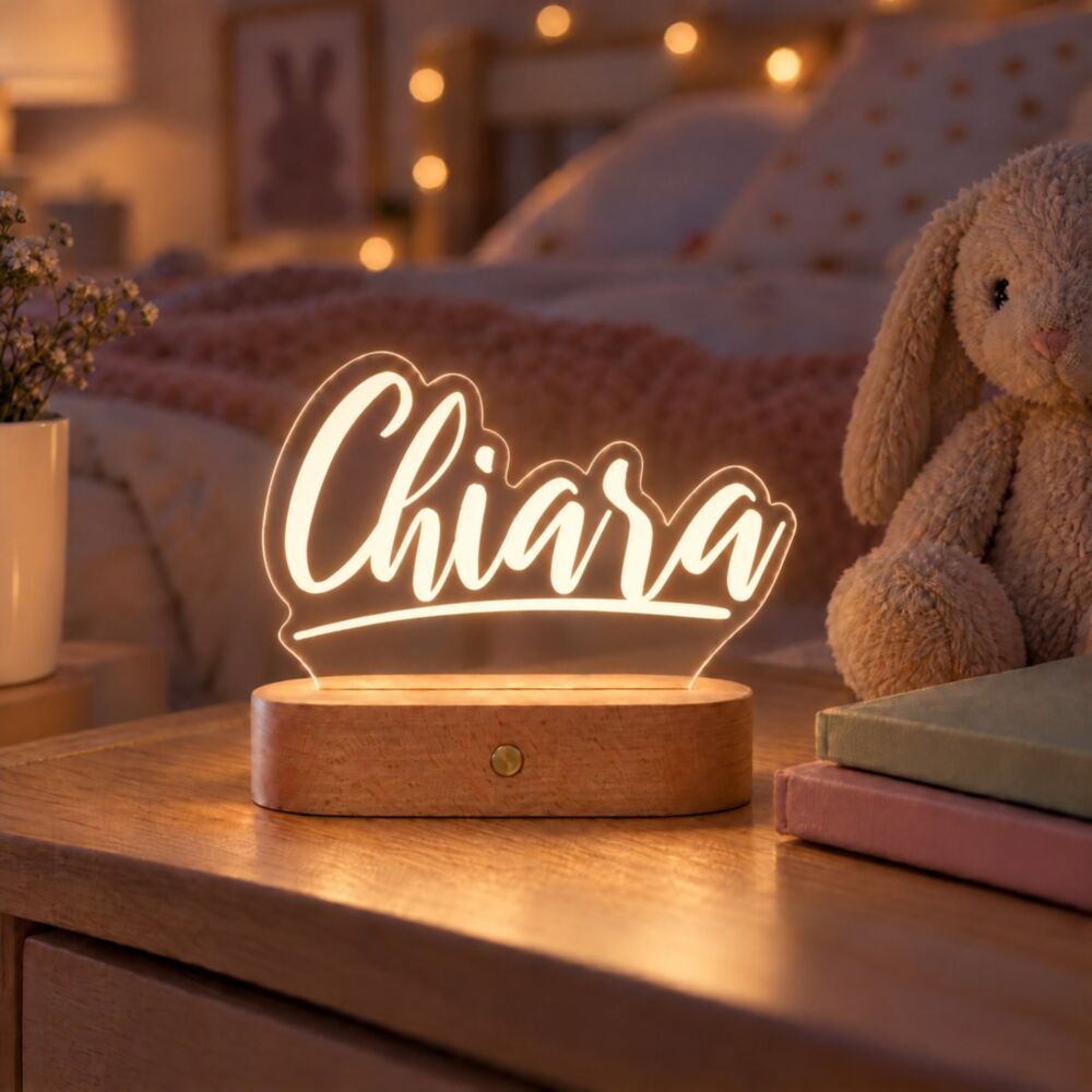 Lampada LED personalizzata con il nome «Chiara» in luce bianca calda sul comodino della cameretta